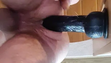 Stepdaddy Fucks Herself in the Ass with a Big Thick Black Dildo in the Door Frame and Cums.