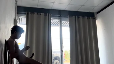 A Handsome Young Man Jerks off in Front of a Glass Door